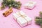 Tied gift package on pink background with pine branch