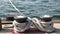 Tied rope knot on metallic bollard with stars, seafaring port of San Diego, California. Nautical ship moored in dock. Cable tie