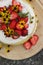 tiered layered cake with yellow wildflowers and strawberries wood board summer cake