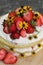 tiered layered cake with yellow wildflowers and strawberries wood board summer cake