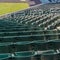 Tiers of green seats for spectators at a stadium