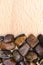 Tiger`s Eye heap jewel on half light wood texture. Pile mineral pebbles background. Place for text