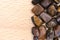 Tiger`s Eye heap jewel on half light wood texture. Pile mineral pebbles background. Place for text