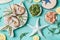 Tiger shrimps and North Sea crabs on light blue background with seaweeds in bowls, top view