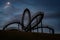 Tiger and Turtle, walkable roller coaster sculpture with illuminated stair railing at night, art installation and landmark in