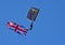 The Tigers Army Parachute Display Team flying large Union Flag against blue sky.