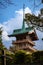 Tight shot of Daiun-in Temple Pagoda with aquamarine green ceiling and a spike framed with trees and a