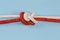 Tightened rope sliding figures of eight knot on blue background