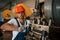 Tightens details of machine by wrench. Man in uniform works on the production. Industrial modern technology