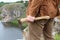 Tightly clenched axe in the hand of a man against the background of the river landscape on a summer day