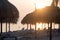 Tiki hut umbrellas, thatch. Sunrise view on beach in Tunisia. Sousse