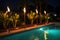 tiki torches around a swimming pool