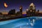 Tiki torches at rooftop pool and downtown skyline with Frost Bank Tower from Westin hotel at night in Austin, Texas USA