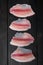 Tilapia fish skinless meat, on black wooden table, top view