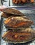 Tilapia fried fish on steel grille. It is a side dish.