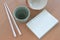 Tile bowl and white chopsticks wooden placed beside the book on