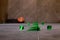 Tile levelling system, four plastic green clips with wedges. Close-up view, selective focus, blurred background