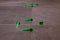 Tile levelling system, four plastic green clips with wedges. Close-up view, selective focus, blurred background