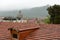 Tile roofs of central part of Mtskheta and view of Svetitskhoveli Cathedral on foggy rainy morning