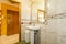 Tiled bathroom with faux marble trim around framed mirror and white