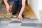 Tiler laying floor tiles on adhesive