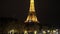 Tilt down Gimbal shot of Eiffel tower in Paris at night. Warm glowing huge metal construction