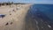 tilt footage of the blue ocean water along the coastline with people relaxing in the sand with beachfront homes