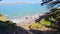 tilt footage of the Golden Gate Bridge at Mile Rock Beach with blue ocean water, waves, rocks and trees at Golden Gate Park