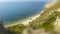 Tilt-Shift photography sandy beach, surrounded by green hills. Top view of the seashore.