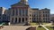 Tilt shot of the Georgia Capitol Museum with statues and lush green grass and plants in the courtyard