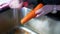 Tilt shot of hands peeling carrot with vegetable peeler
