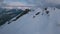 Tilt up aerial shot amazing high mountains valley white fluffy snow surrounded by fog