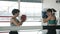 Tilt-up portrait of confident young sportswomen training in boxing ring in gym together