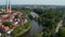 Tilt up reveal of Luebeck Cathedral, large brick-built Lutheran church. Forwards fly above Trave river flowing around
