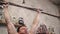 Tilt up of shirtless sportsman doing pull-ups on bars during cross-training workout at gym