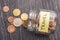 Tilted glass jar with scattered euro coins with the inscription TRAVEL on a black wooden table