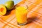 tilted shot of mango juice on a colorful tabletop