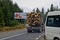 A timber carrier with cargo transports logs along a mountain road.
