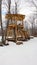 Timber fort structure in a rural snow setting with hammock