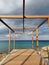 A timber-framed observation deck over the turquoise waters of the Mediterranean against a dramatic sky