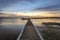 Timber jetty leading to colourful sky at dusk