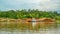 Timber loaded into big barge then drag by a tugboat cruising Mahakam River