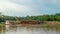 Timber loaded into big barge then drag by a tugboat cruising Mahakam River