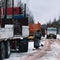 Timber truck loaded with logs driving snowy road