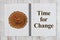 Time for Change on journal notepad with wood clock