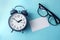 Time concept with blank white paper note copy space to add wording or message , alarm clock with a reading eyeglasses decoration