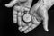 Time concept. Vintage clock in old senior wrinkled male hands on black background