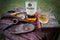 Time for a drink - glass of whisky on a table with a book, bottle, pipe and wooden bowl