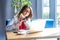 Time is gone. Portrait of serious young woman in glasses sitting, looking at laptop screen on video call and pointing at her smart