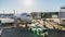 Time-lapse of airplane landing and docking at airport terminal gate, airport staff security check and unloading luggage, zoom out